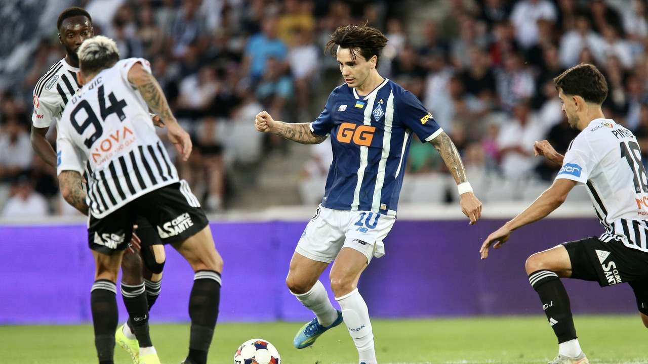 Two footballers challenge for possession near the touchline