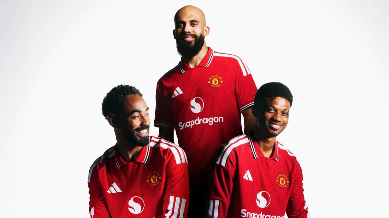 Manchester United players stand together in red shirts