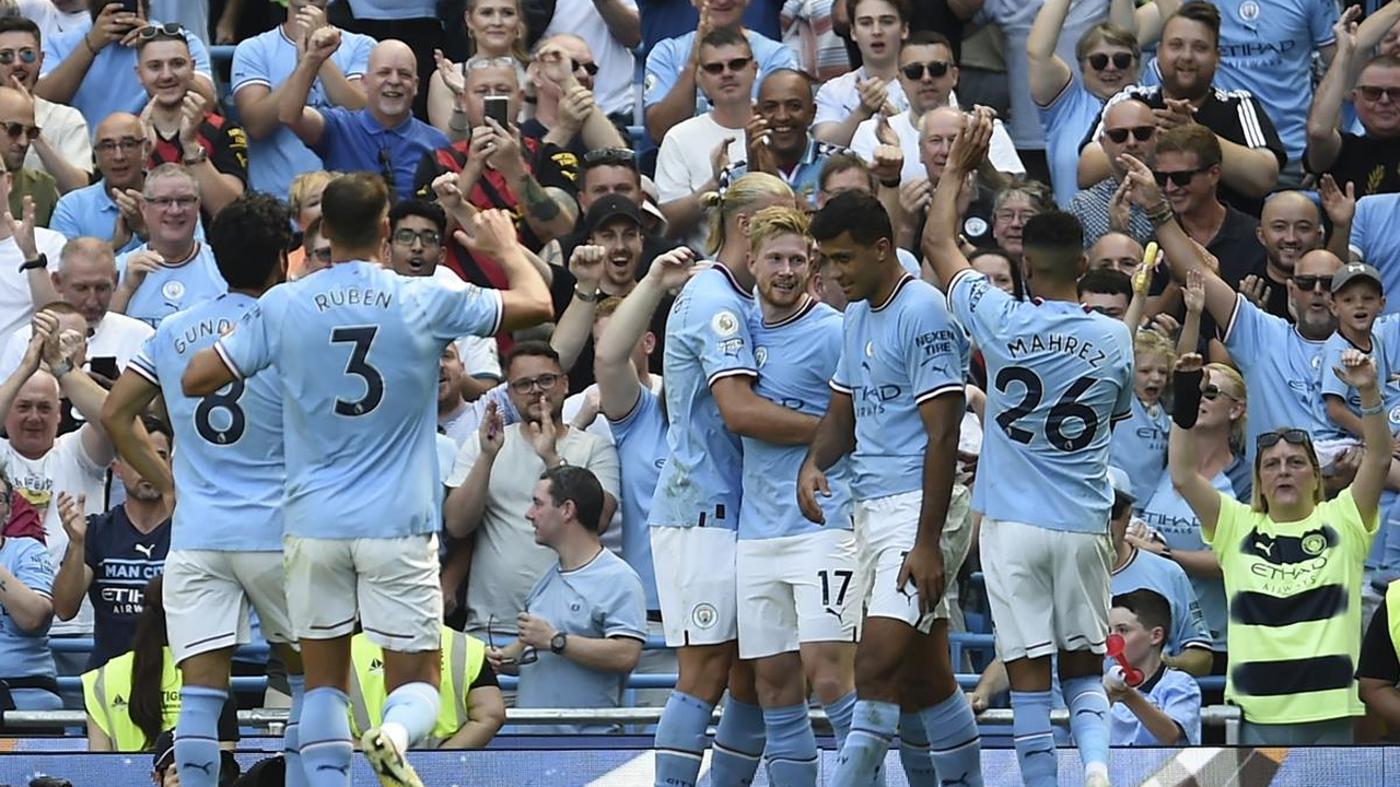 Manchester City players celebrate together near the supporters