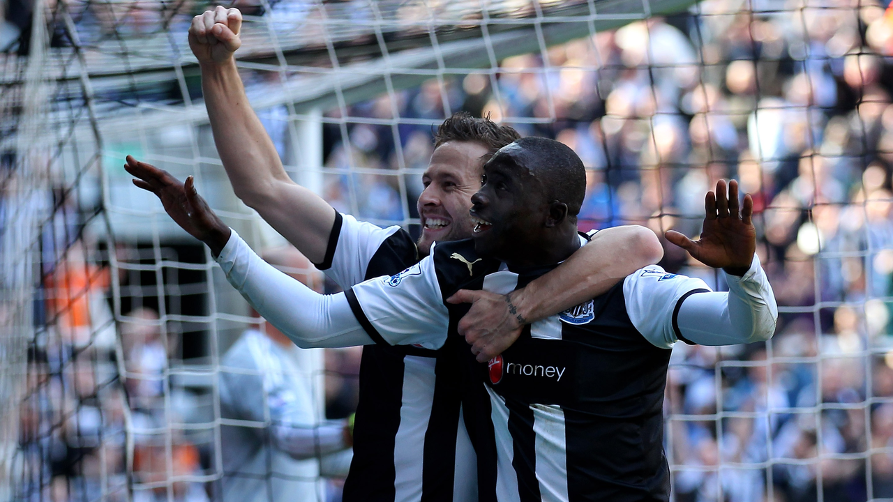 Newcastle players celebrate a goal in front of the net