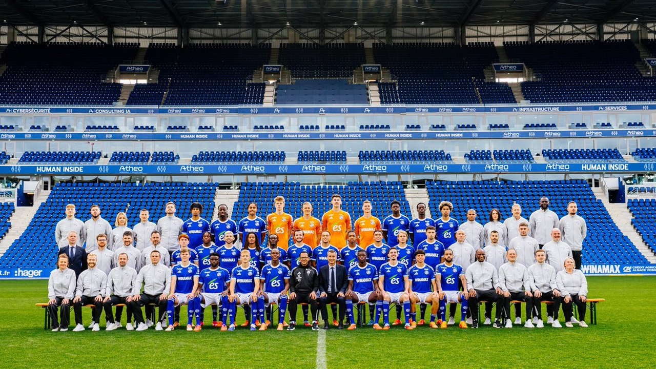Two football squads pose together on the pitch
