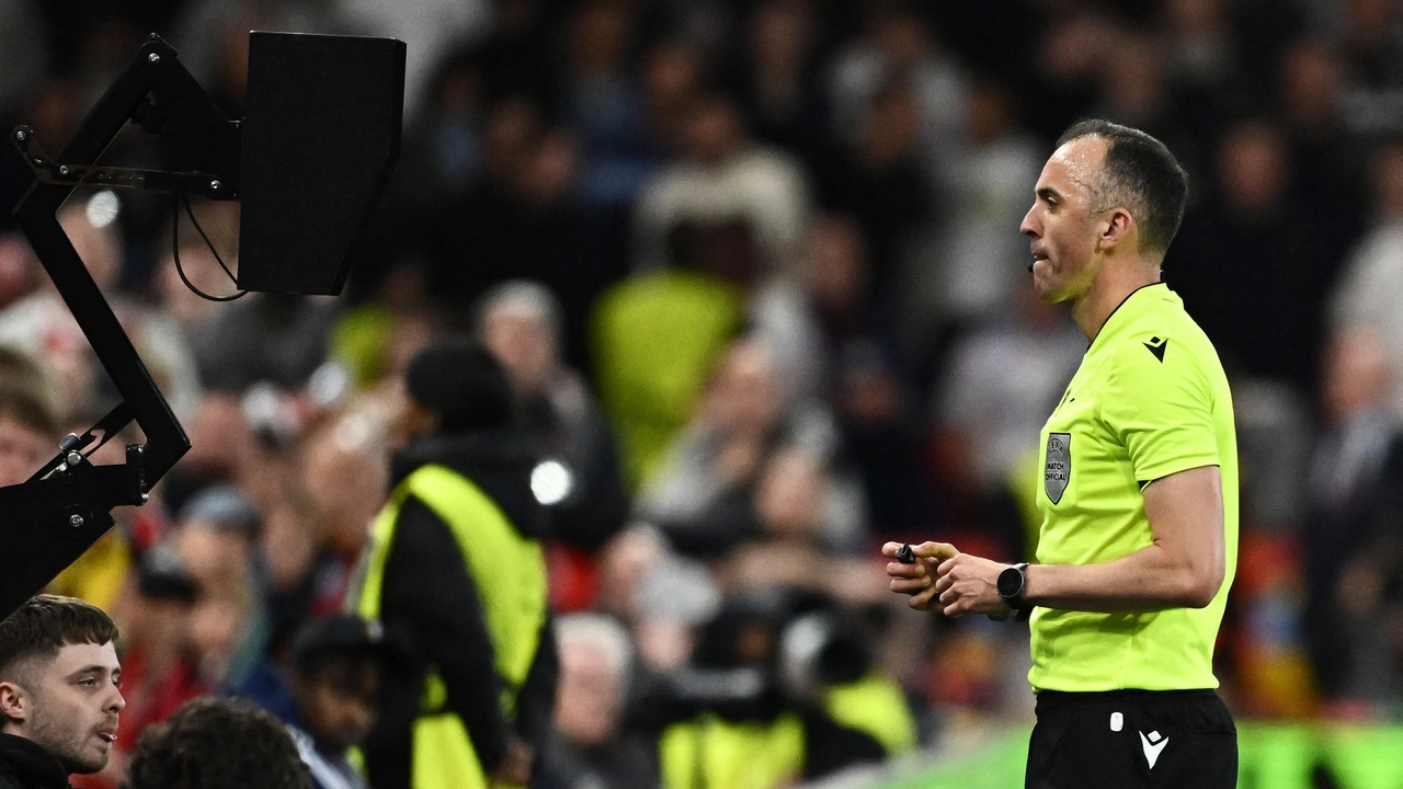 A football referee shows a card during a match